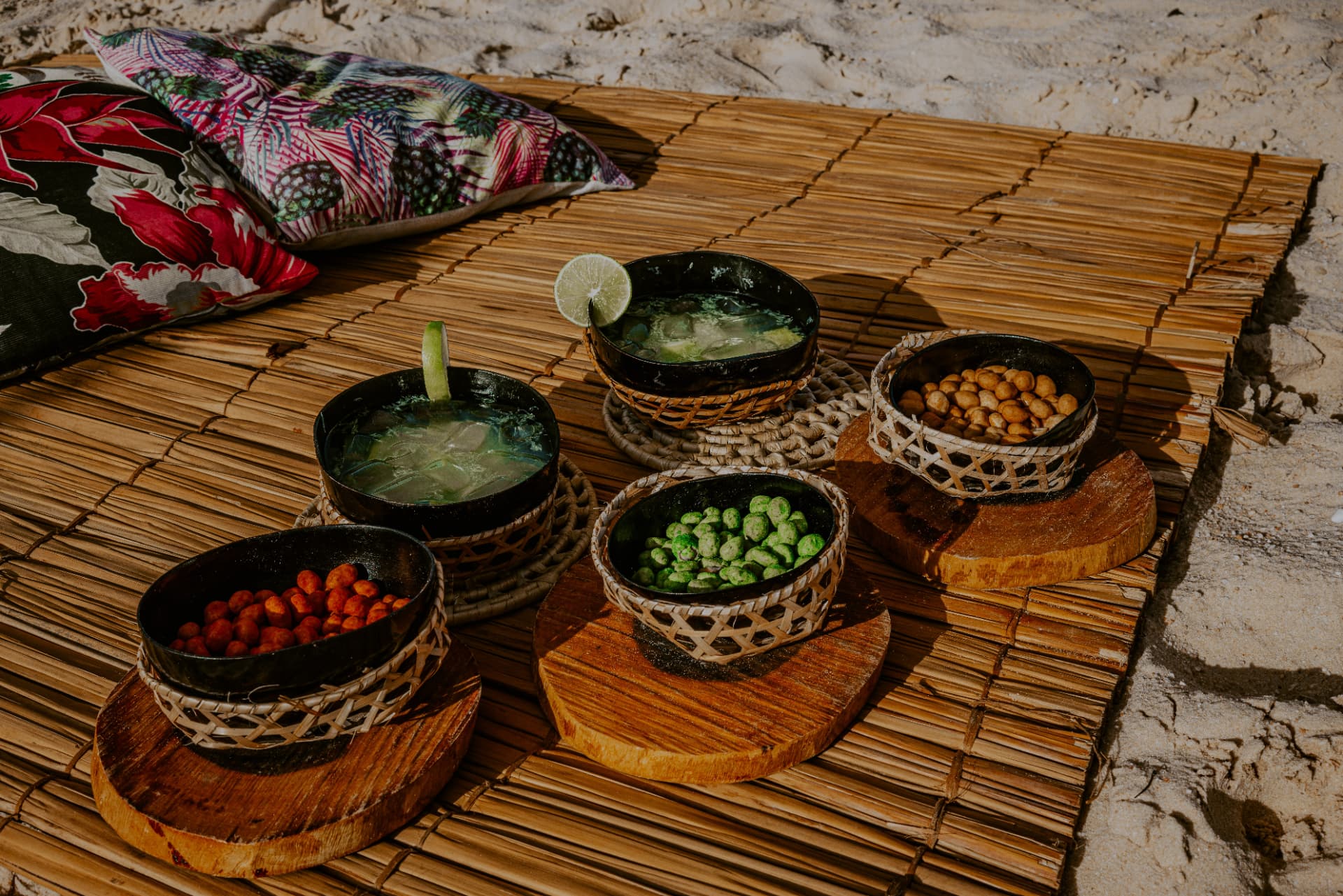 Regional drinks and snacks served on a woven mat by the river